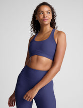 blue ribbed racerback bra with overlapping hemband detail and a scoop neckline.