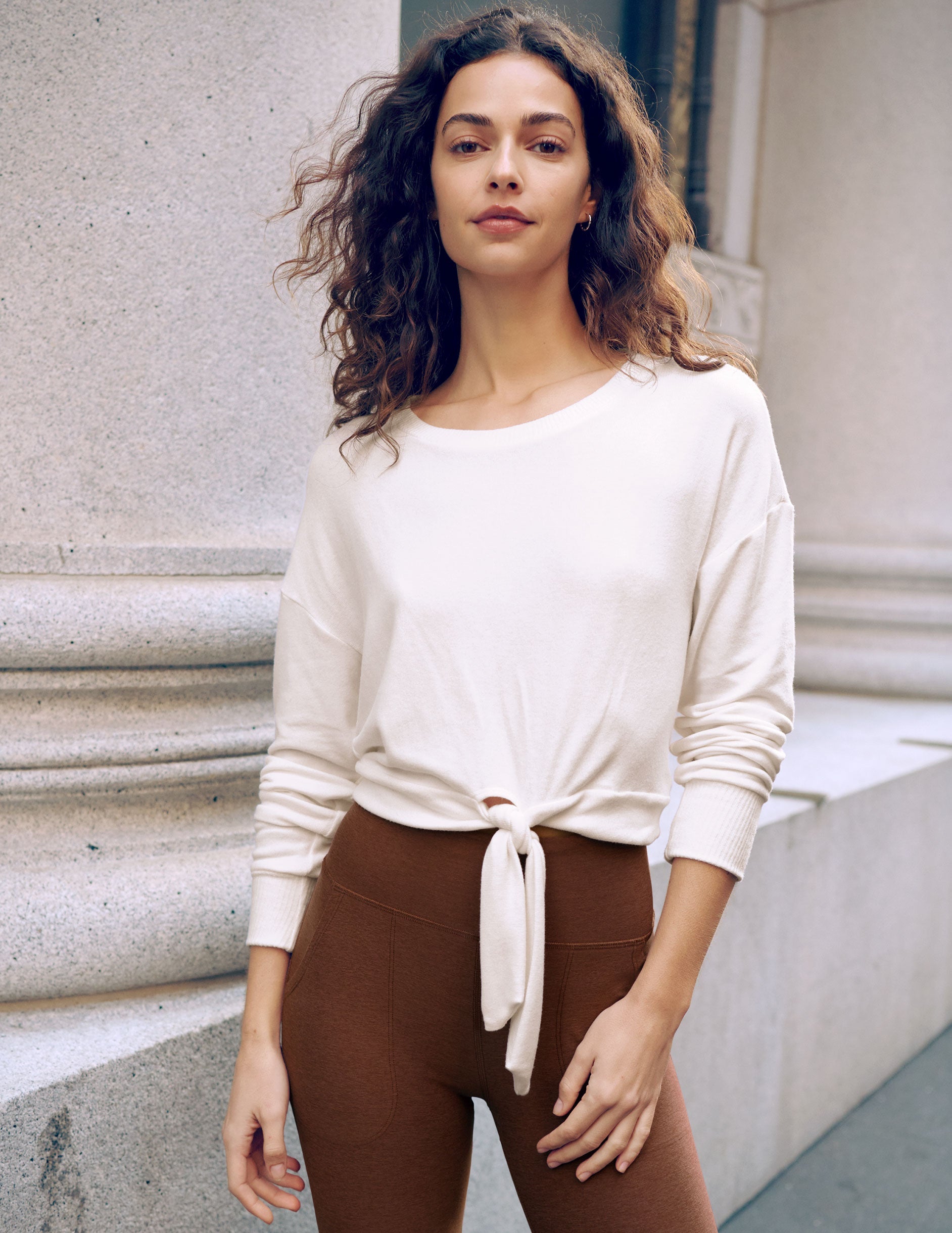 white scoop neck cropped pullover with a front tie detail.