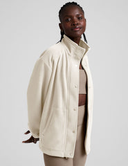 white fleece button up jacket with a full front zip and snap closures and pockets.