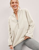 white fleece quarter zip jacket with a kangaroo pocket.