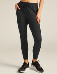 black high-waisted midi joggers with pockets and a drawstring at waistband