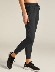 black high-waisted midi joggers with pockets and a drawstring at waistband