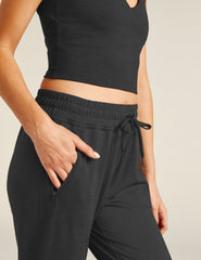 black high-waisted midi joggers with pockets and a drawstring at waistband