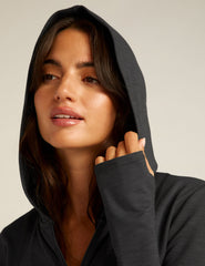 black zip-up jacket with a hoodie and thumb holes.