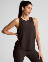 model wearing a brown sleeveless scoop neck top and leggings on a plain background.