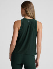 model wearing a green relaxed fit tank top and leggings against a plain background.