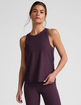 model wearing a purple relaxed fit tank top and leggings on a light gray background.