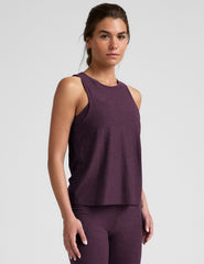 model wearing a purple relaxed fit tank top and leggings on a light gray background.
