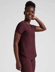 model is wearing a maroon t-shirt and leggings against a plain background.