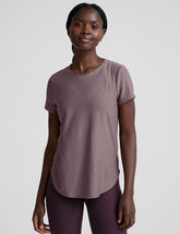model wearing a mauve t-shirt and leggings on a plain background.