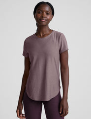 model wearing a mauve t-shirt and leggings on a plain background.