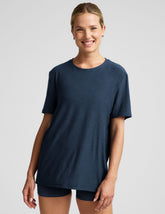 model wearing a blue oversized men's t-shirt and biker shorts against a plain background.