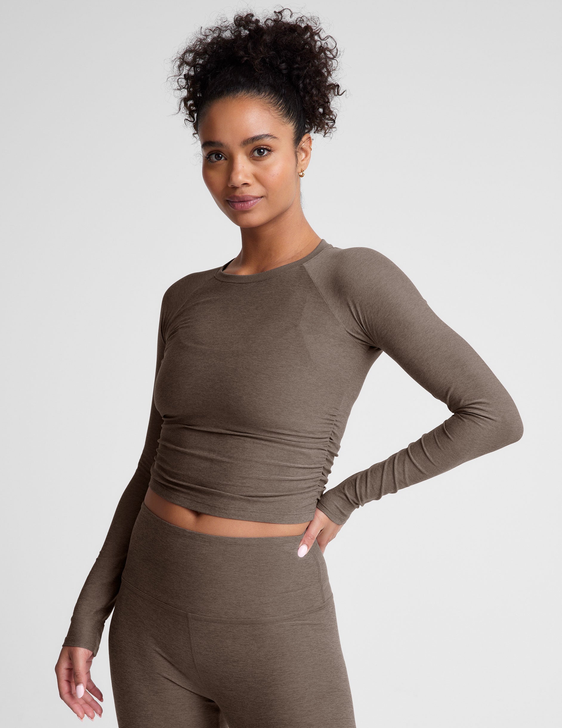 brown long sleeve cropped top with shirred detailing on the sides.