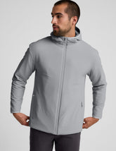 Man wearing a gray jacket and gray pants on a light gray background.