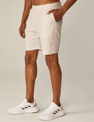 model is wearing white men's sweatshorts with pockets.