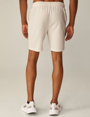 model is wearing white men's sweatshorts with pockets.