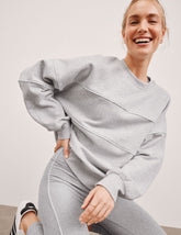 gray fleece crewneck sweater with white contrast piping trim at chest and sleeves.