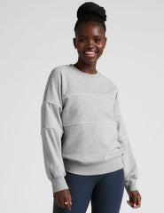 gray fleece crewneck sweater with white contrast piping trim at chest and sleeves.