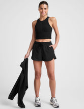 black shorts with a 2.5" inseam, encased elastic at waistband with drawcord, self binding at hem edges, side zipper pockets, and interior performance lining shorts.