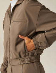 brown zip-up jetstretch woven jacket with a collar and pockets.