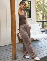 model is wearing brown spacer style pants with pockets against a plain background.