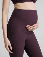 person wearing purple maternity bootcut style pants against a plain background.