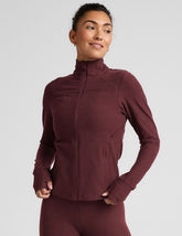 red zip-up mock neck jacket with pockets and thumbholes.