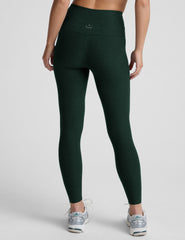 model wearing green high-waisted full length leggings on a plain background.