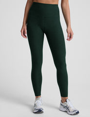 model wearing green high-waisted midi length leggings on a light background.