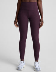 model wearing purple high-waisted midi length leggings on a light background.
