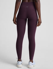 model wearing purple high-waisted midi length leggings on a light background.