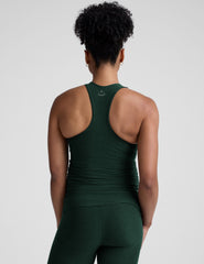 model wearing a green maternity racerback tank and green maternity midi length leggings on a plain background.
