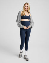 pregnant woman wearing a blue racerback bra and blue maternity midi leggings.