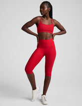 red high-waisted pedal pusher length leggings.