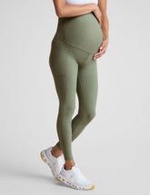 green high-waisted maternity leggings with pockets.