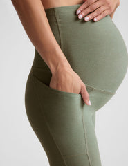 green high-waisted maternity leggings with pockets.