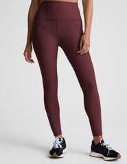 red high-waisted midi length leggings with pockets.