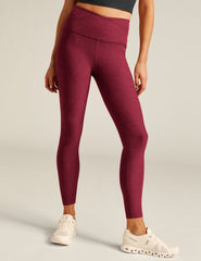 red high-waisted midi leggings with a crossover detail on the front waistband.