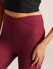 red high-waisted midi leggings with a crossover detail on the front waistband.