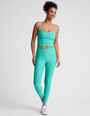 blue high-waisted midi length leggings with a crossover detail on the front waistband.