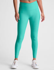 blue high-waisted midi length leggings with a crossover detail on the front waistband.