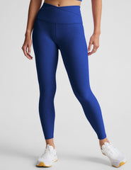 blue high-waisted midi leggings with a crossover detail on the front waistband.