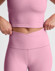 pink high-waisted midi leggings with a crossover detail on the front waistband.