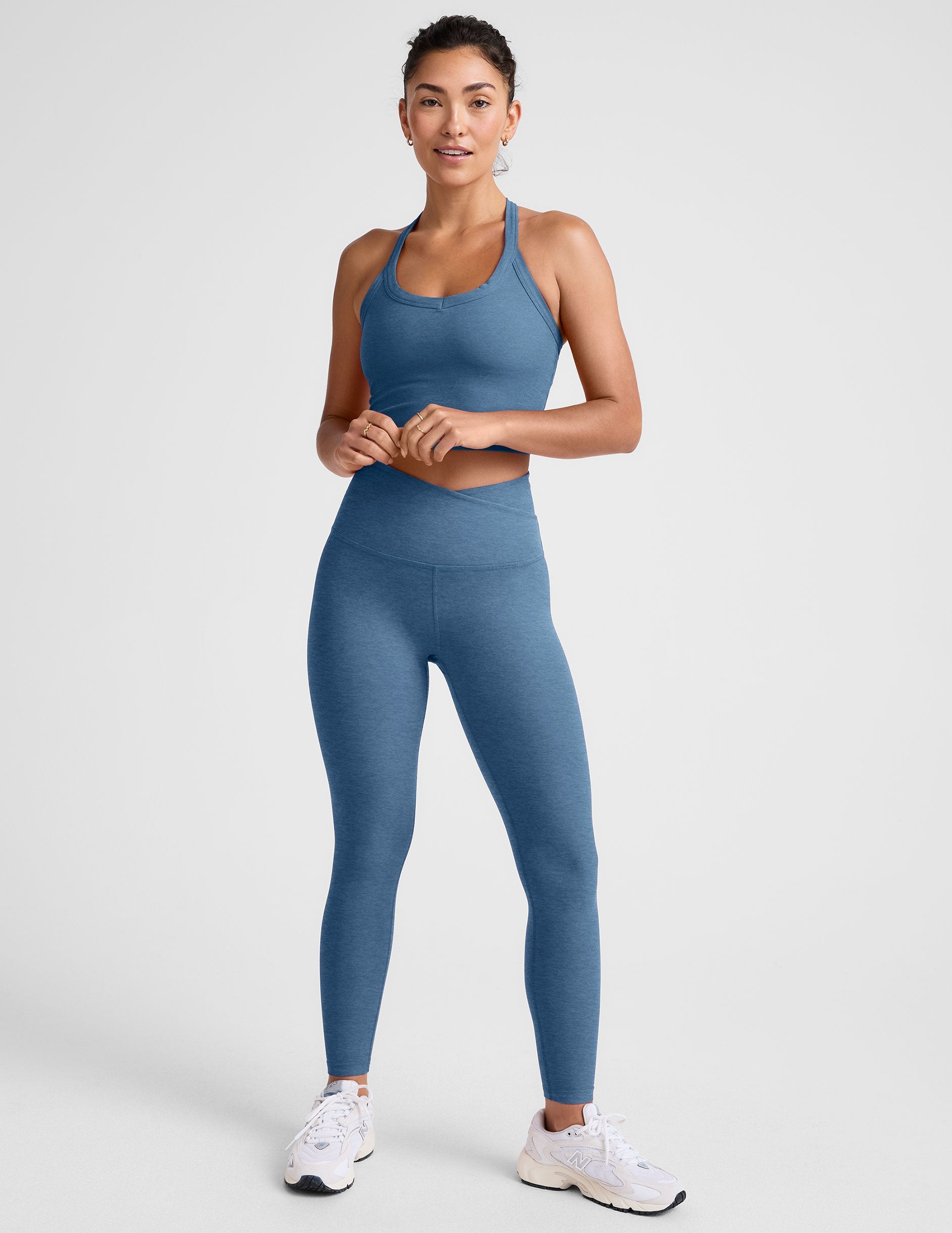 blue high-waisted midi length leggings with an overlapping front v waistband.