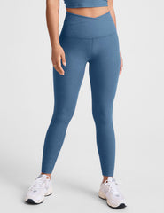 blue high-waisted midi length leggings with an overlapping front v waistband.