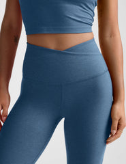 blue high-waisted midi length leggings with an overlapping front v waistband.