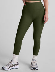 model is wearing green high-waisted capri length leggings with pockets.