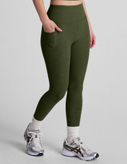 model is wearing green high-waisted capri length leggings with pockets.