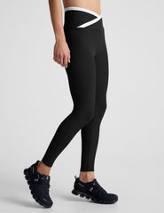 black high-waisted midi length legging with white contrast binding at crossover waistband.
