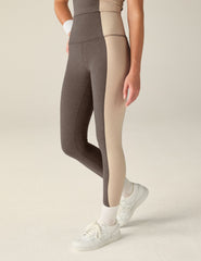 brown high-waisted midi leggings with eggshell outline details on the sides.